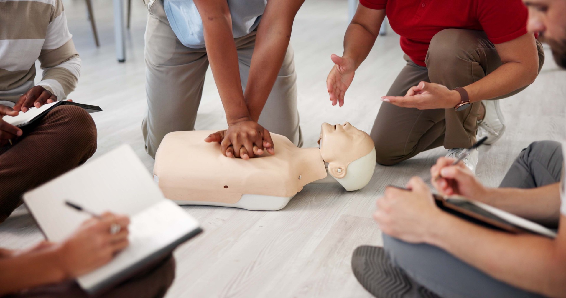 Personnes, mannequin ou mains dans le bureau pour la RCR, l’atelier de premiers secours ou la leçon de compression thoracique. Collègues, pratique d’urgence ou mannequin en agence pour la procédure de sauvetage, les notes ou l’engagement des emplo